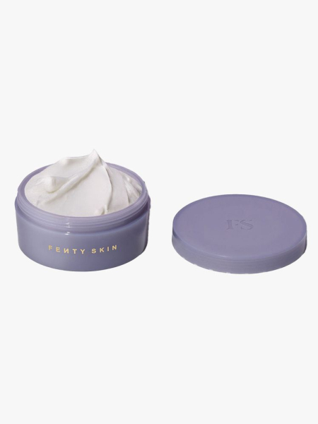 An open purple tub of Fenty Beauty Butta Drop Whipped Oil Body Cream in Fenty Fresh Shimmering and cap on a light gray background