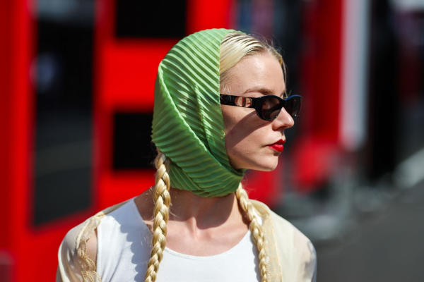 Anya TaylorJoy wears a green scarf and pigtail braids to an F1 event.