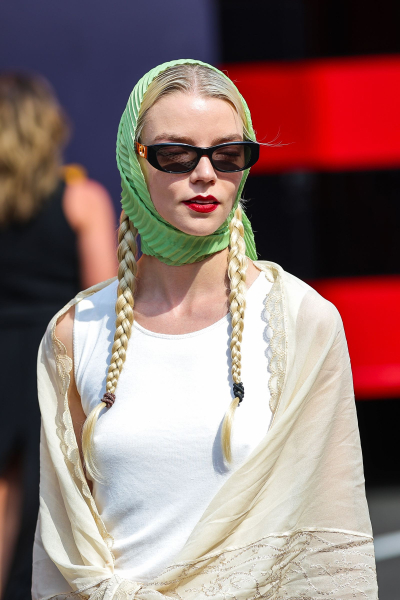 Anya TaylorJoy wears a green scarf and pigtail braids to an F1 event.